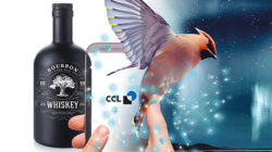 Whiskey bottle with mobile phone and hummingbird