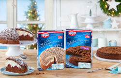 Oetker baking mixes: Winter Plum Cake and Chocolate Orange Tart. On a table next to a sliced tart and chocolate cake