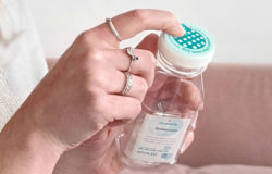 A person explores the touchcap bottle closure with an index finger.