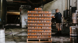 Pallet of beer cans in warehouse with man